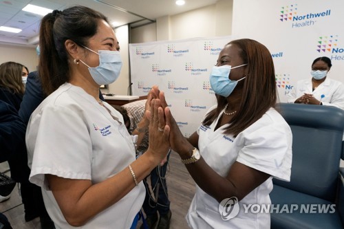 첫 백신 접종 후 다른 간호사로부터 축하받는 샌드라 린지